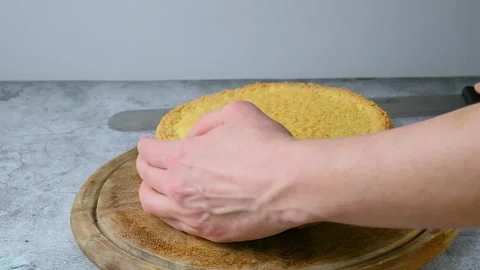Women's hands put a cut biscuit cake next to another cake on the kitchen table.  Stock Footage 256656245
