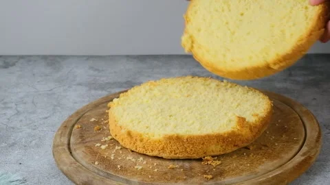 Women's hands put a cut biscuit cake next to another cake on the kitchen table.  Stock Footage 256656464
