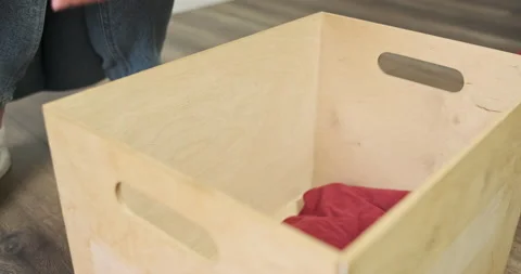 Women's hands put different clothes in box. Side view, indoors. Concept of Vídeos de archivo 235342876