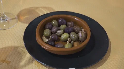 Women's hands put olives from a tin can in a porcelain plate at restaurant Video stock 84929409