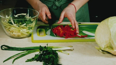 Women's hands put red pepper in a bowl with salad Stock Footage 103954371