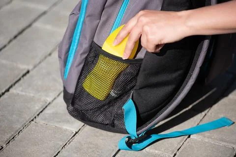 Women's hands put sunscreen in a backpack for a hike against the background.. Stock Photos