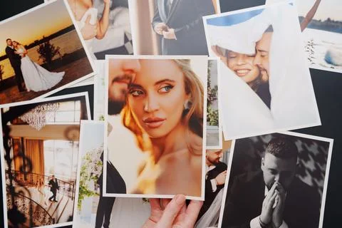 Women's hands put on the table and show wedding photos. Foto stock