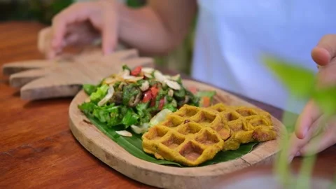 Women's hands put on the table a small plate made of wood in the shape of a Stock Footage 216697350