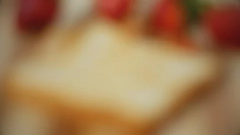 Women's hands putting cheese spread on a toasted white bread.  Strawberry san Stock-Footage 108790115