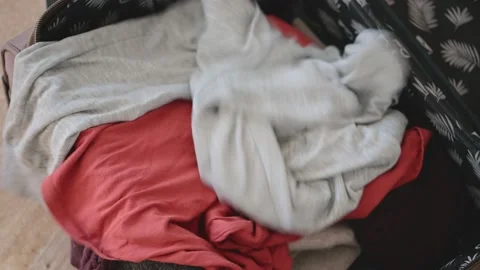 Women's hands quickly tosses clothes into an open suitcase. Hurrying Stock Footage 154798772