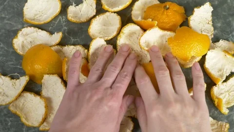 Women's hands remove the peel of mandarin from the table . 4k, slow-motion Stock Footage 83007659