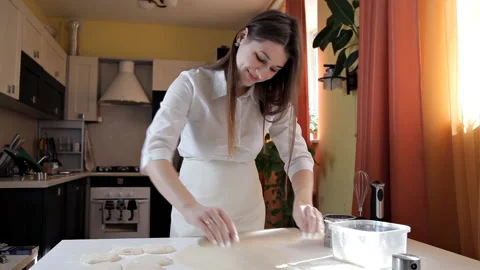 Women's hands rolling dough for baking with a rolling pin on a light table Stock Footage 104837839