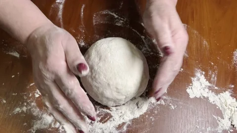 Women's hands shape homemade bread before baking. 動画素材 238457347
