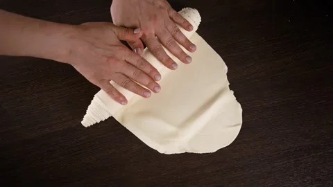 Women's hands slowly roll the thin dough into a roll. Stock Footage 256152795
