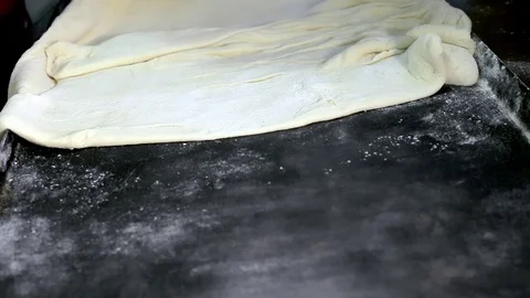 Women's hands spread out on a baking sheet rolled dough Video stock 100854765