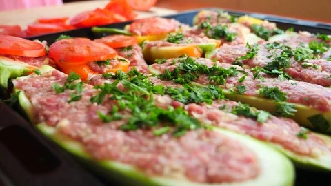 Women's hands, spread thin tomato slices on stuffed zucchini. close-up. 4k, slow Stock Footage 81050337