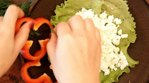 Women's hands spread vegetables on a plate, close-up Stock Footage 85493693