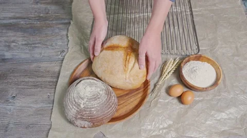 Women's hands spread white round fresh bread from the grate, and put it next to Stock Footage 201292798