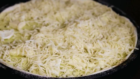 Women's hands sprinkle with cheese round pizza Stock Footage 92331343