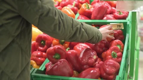 Women's hands in store, vegetable shop chooses red peppers Stock Footage 150022019