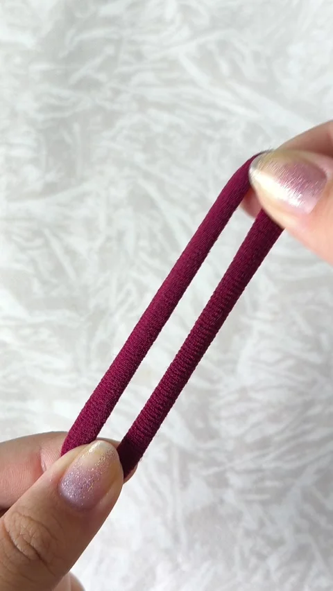 Womens hands stretch an elastic fabric elastic band for hair. Hair accessories. 스톡 동영상 313979484