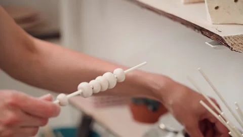 Women's hands string decorative ceramic elements and create handmade clay decor 库存影片 196234823
