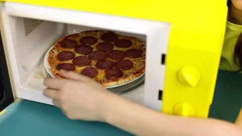Women's hands take out the finished pizza from the microwave Stock Footage 161874626