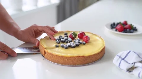Women's hands take out a piece of cut cheesecake with fresh berries in the Stock Footage 137597718