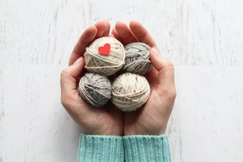 Women's hands with tangles of knitting threadons on a white background Stock Photos