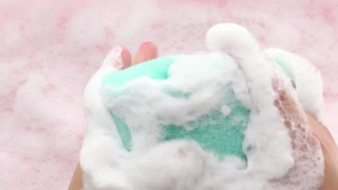 Women's hands in thick foam smooth out the washcloth and slowly squeeze it Part2 Stock Footage 281358405