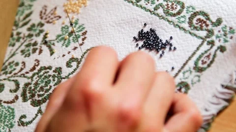 Women's Hands Thread Beads on a Long Needle and Make a Bracelet Stock Footage 257973161