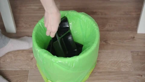 Women's hands at throw plastic propylene black food containers into the trash Stock Footage 153202488