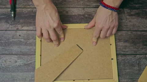 Women's hands top view inserting a photo into a photo frame. Stock Footage 242343741