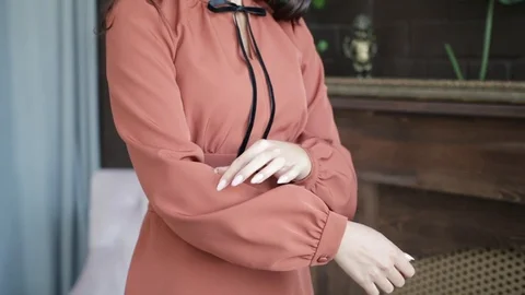 Women's hands touch chic red dress, hands touch black ribbon, close-up, slow Stock Footage 103784446