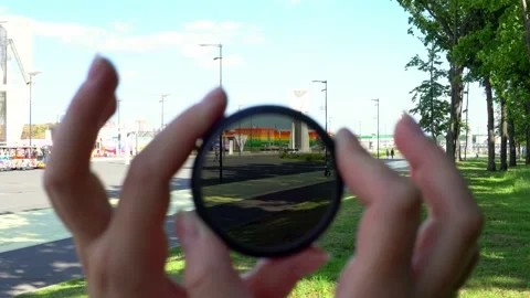 Women's hands twist the ND filter and it becomes transparent Video stock 201097437