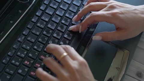 Women's hands type on the black keyboard of the laptop Stock Footage 156905487