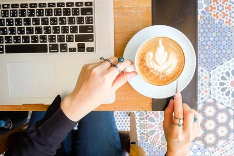 Women's hands typing on computer with coffee Stock Photos