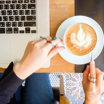 Women's hands typing on computer with coffee Stock Photos