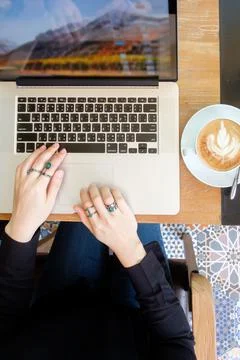 Women's hands typing on computer with coffee Stock Photos