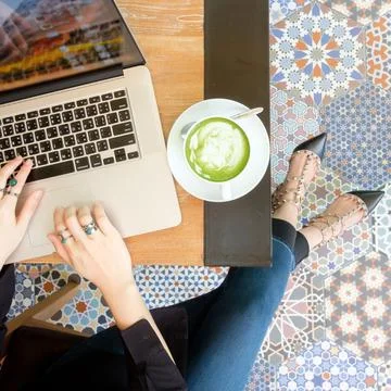 Women's hands typing on computer with hot green tea Stock Photos