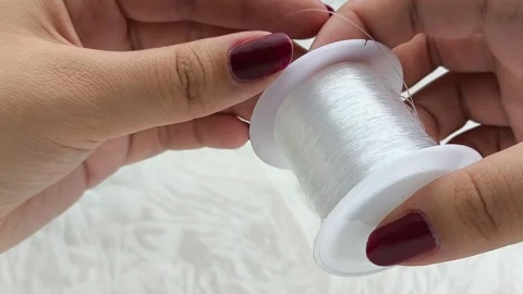 Womens hands unwrap plastic wire for beading. Stock Footage 314308396