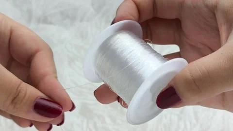 Womens hands unwrap plastic wire for beading. Stock Footage 314308413