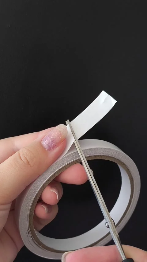 Womens hands use scissors to cut off double-sided tape. Stock Footage 315154953