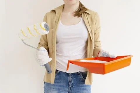 Womens hands using paint roller while working indoors Stock Photos