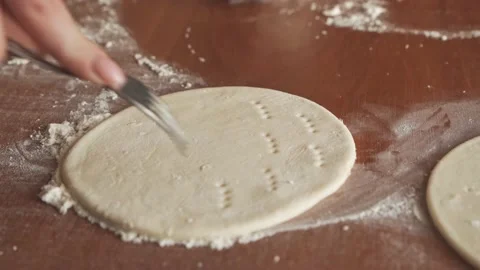 Women's hands, using a rolling pin, roll out the dough for baking. Stock Footage 186002684