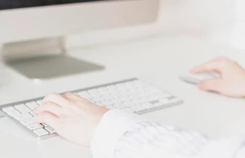 Women's hands using a wireless keyboard and mouse Stock Photos