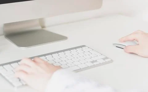 Women's hands using a wireless keyboard and mouse Stock Photos