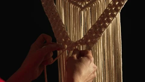 Women's hands weave a macrame pattern in creative workshop on black background Stock Footage 172241019