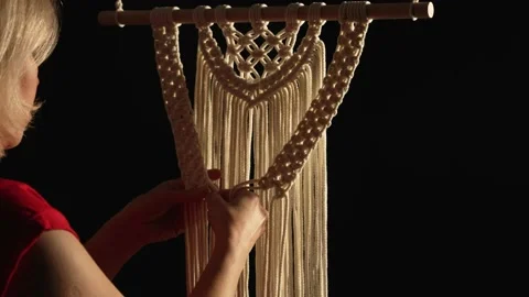 Women's hands weave a macrame pattern in creative workshop on black background Stock Footage 172241032