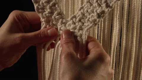 Women's hands weave a macrame pattern in creative workshop on black background Stock Footage 172241354