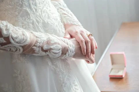 Women's hands on a white wedding dress. show her wedding ring with box Stock Photos