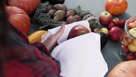 Women's hands wipe apple with a white towel at the market. Top view. Hygiene. Stock Footage 139058264