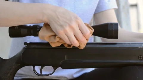 Women's hands wipe dust from a pneumatic rifle Stock Footage 195953982