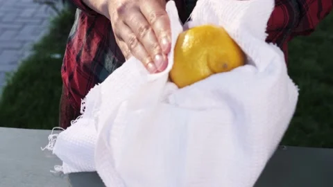 Women's hands wipe lemon with a white towel at the market. Hygiene. Stock Footage 139058296